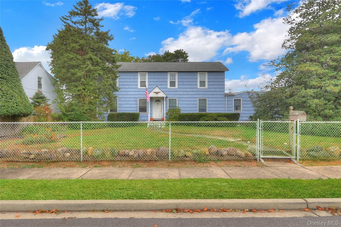 Colonial-style house with a fenced front yard and a gate