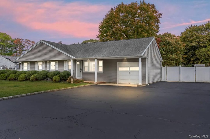 Single story home with asphalt driveway, an attached garage, and roof with shingles
