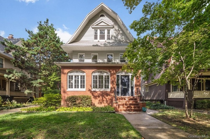 View of front facade with brick siding and a front yard