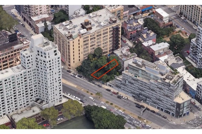Aerial view of property's location featuring property parcel outlined and nearby urban area