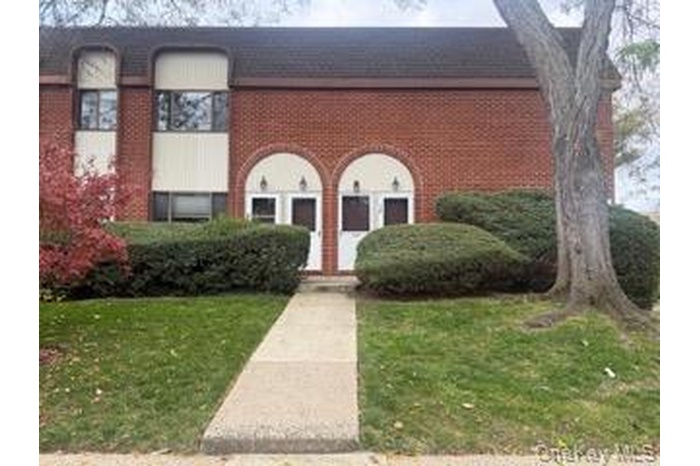 View of front of home with a front yard and brick siding