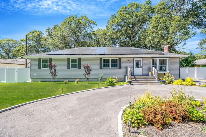Ranch-style home with a chimney and roof mounted solar panels