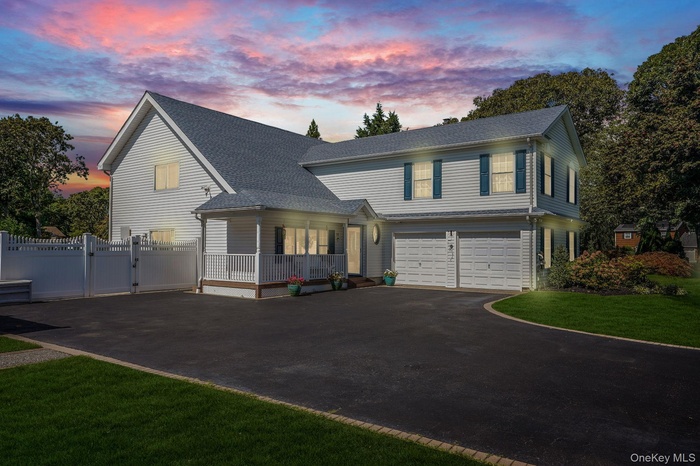 View of front of house with driveway, a gate, a garage, and roof with shingles