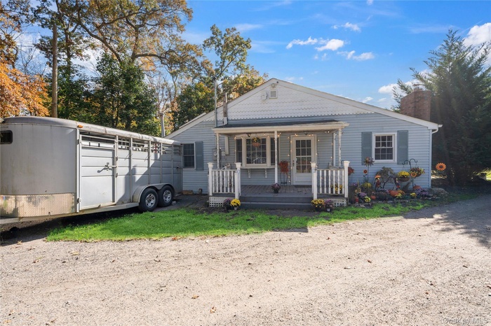 View of front facade with covered porch and a chimney