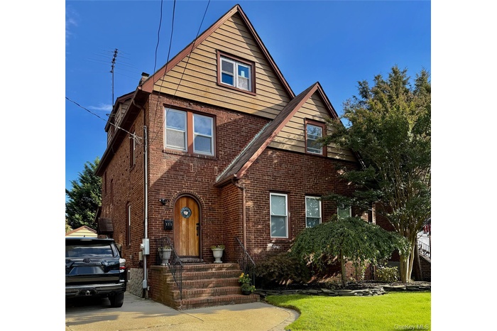 View of front facade featuring brick siding and a front yard