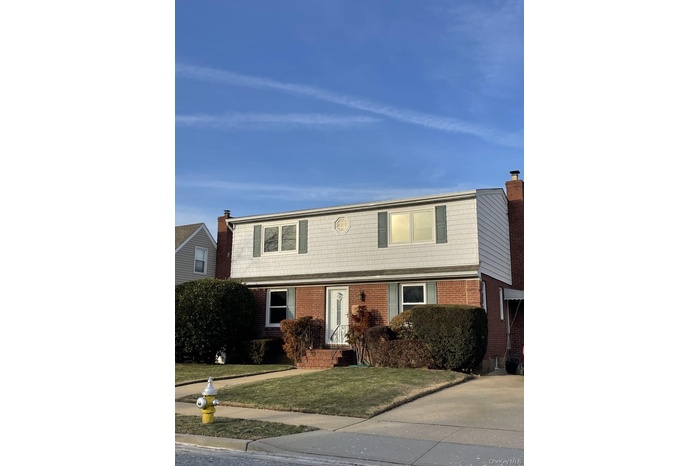 View of front of home featuring a front lawn and brick siding