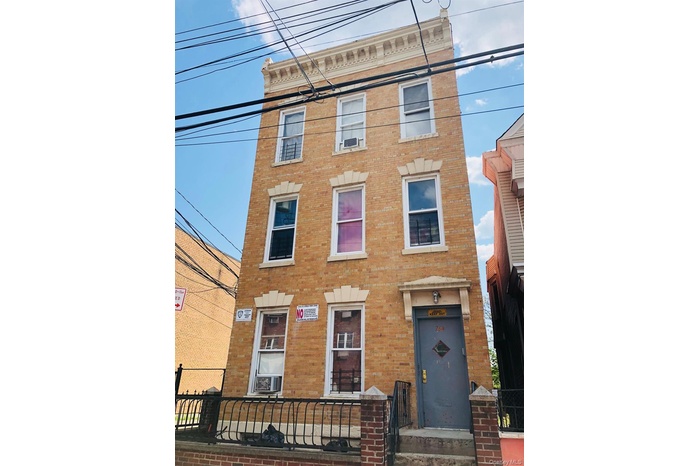 Italianate home featuring brick siding and cooling unit. Building has 3 units plus a bsmt.