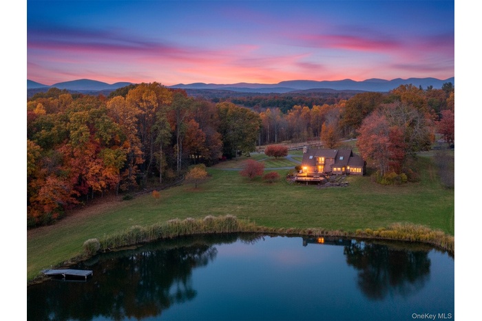 Aerial view at dusk of a water view and a wooded view
