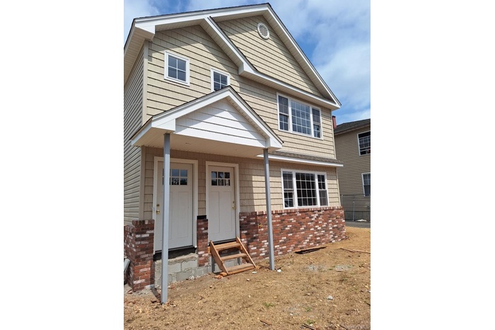View of front of home with a porch and brick siding