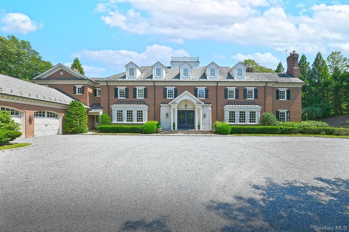 Colonial-style house with french doors, brick siding, a garage, and a chimney