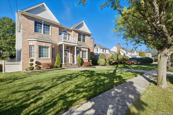 Traditional-style house featuring brick siding, a residential view, and a balcony