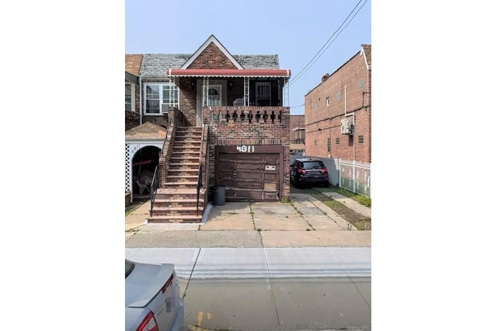 View of front of house featuring brick siding, stairs, concrete driveway, and an attached garage