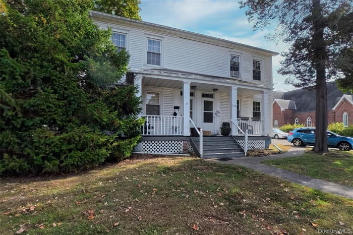 View of front of house featuring a porch and a front lawn