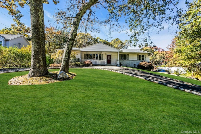 Ranch-style house featuring a porch and a front lawn