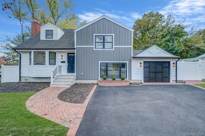 View of front of property with roof with shingles, a chimney, and board and batten siding