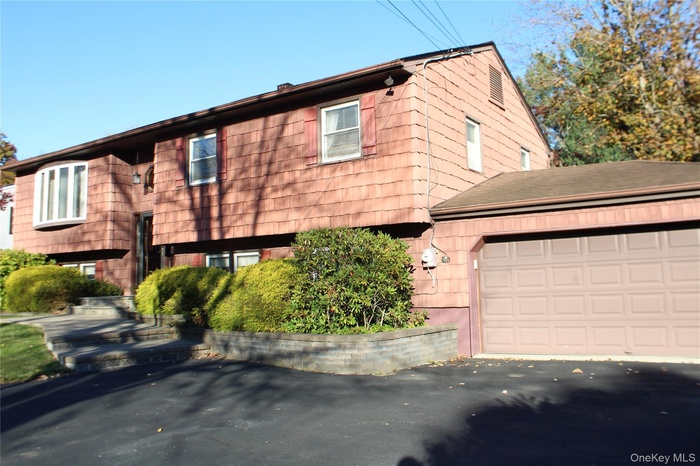 View of front of property with driveway and a 2 car garage