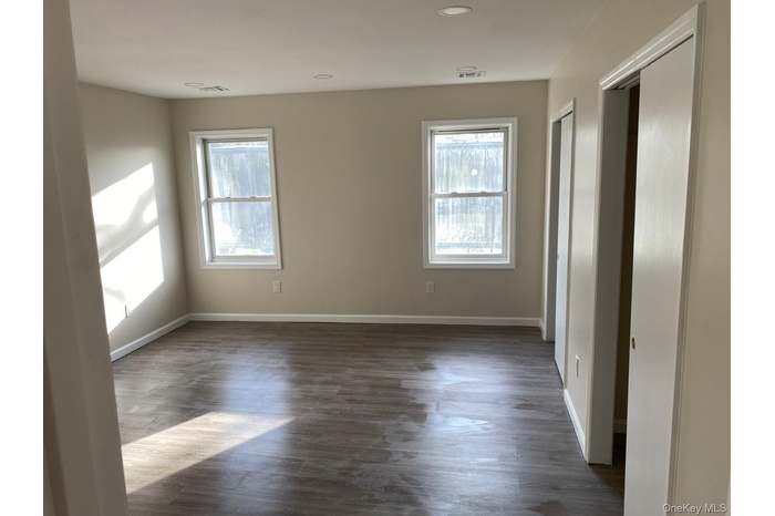 Unfurnished bedroom featuring multiple closets, dark wood-type flooring, and recessed lighting