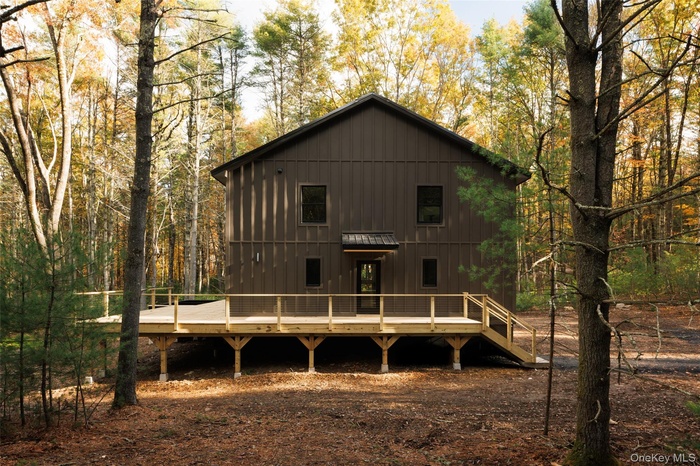 Rear view of property with a deck and a forest view