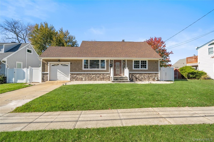 View of front of house featuring a shingled roof, a gate, a garage, and concrete driveway