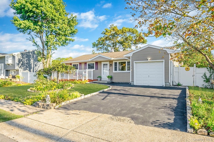 View of front facade featuring driveway, a garage, and a shingled roof