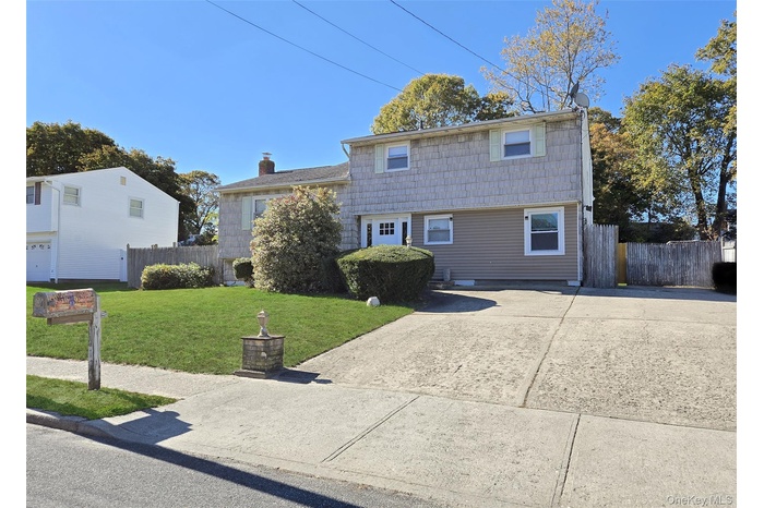 View of front of home featuring a chimney and concrete driveway