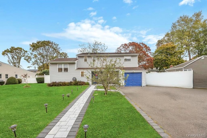 View of front facade with asphalt driveway and a garage