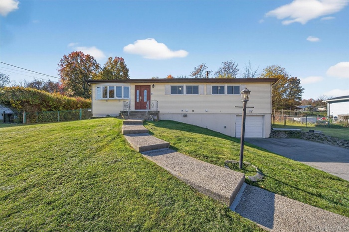 Single story home featuring an attached garage and asphalt driveway