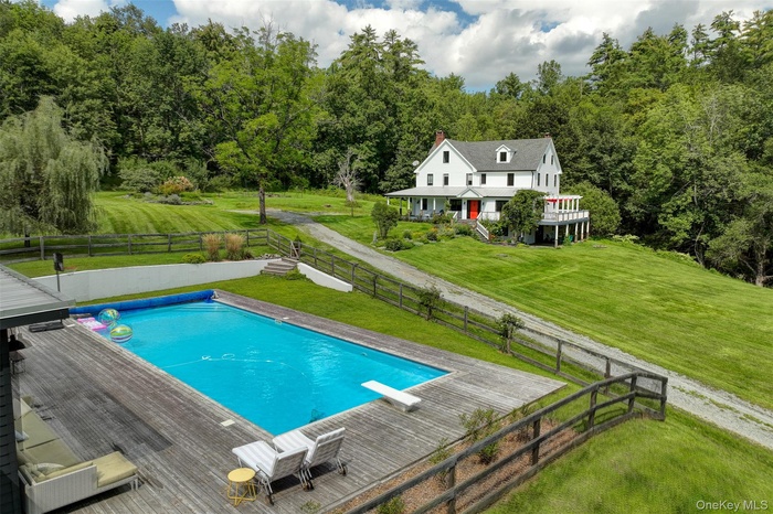 View of pool featuring a yard, a diving board, and a deck