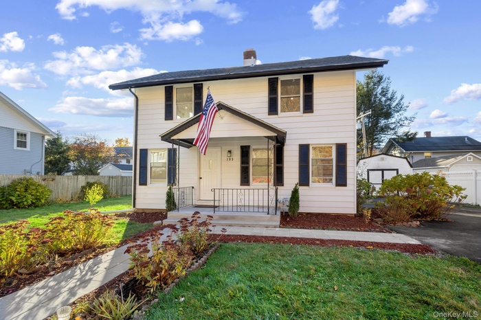 Colonial-style house with a porch and a chimney