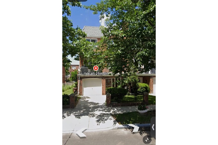Obstructed view of property with brick siding, concrete driveway, a fenced front yard, and roof with shingles