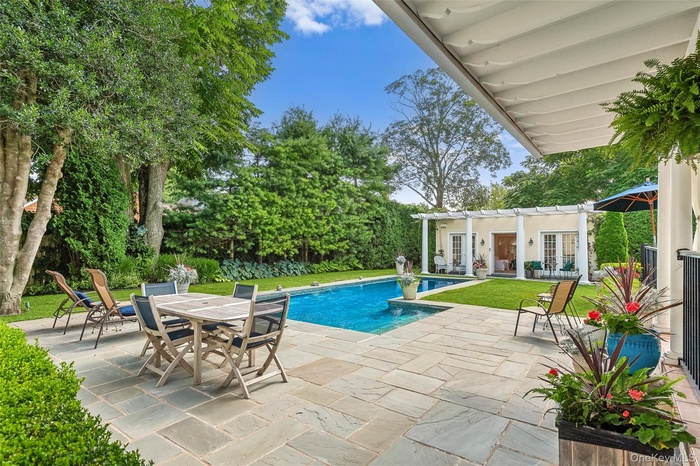 Swimming pool with a patio area, a storage structure, french doors, an outbuilding, and outdoor dining area