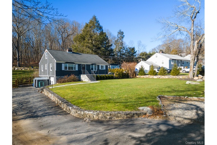 Single story home with a chimney, a front lawn, asphalt driveway, an attached garage, and roof with shingles