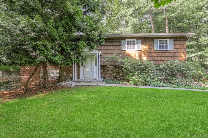 View of front of house with a front lawn and brick siding