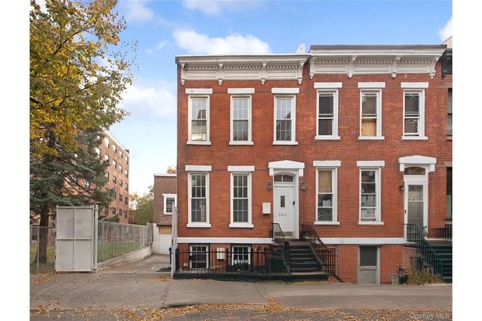 Italianate-style house featuring brick siding and a garage