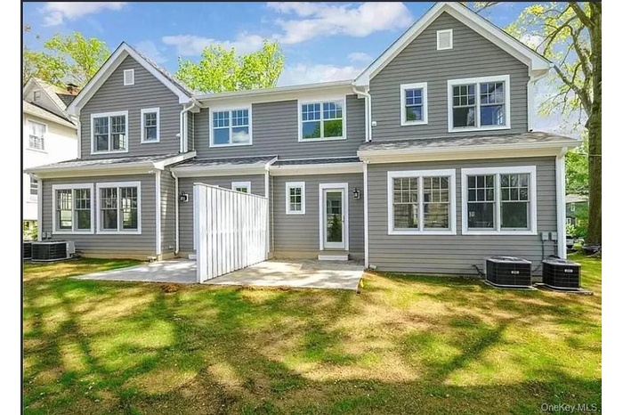 Rear view of house with a patio area and a lawn