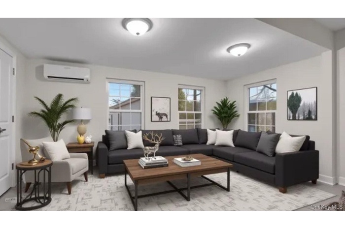 Living room featuring plenty of natural light and a wall mounted air conditioner