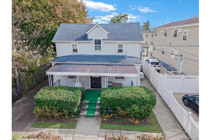 Traditional-style home featuring covered porch and a shingled roof