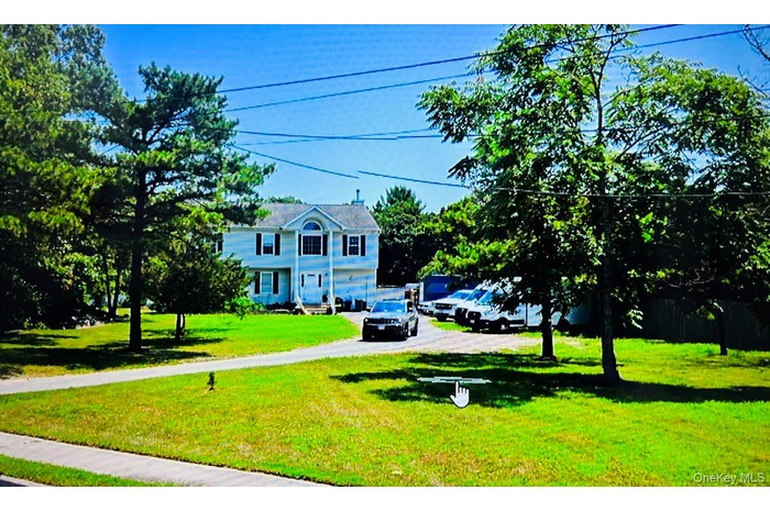 View of grassy yard featuring driveway
