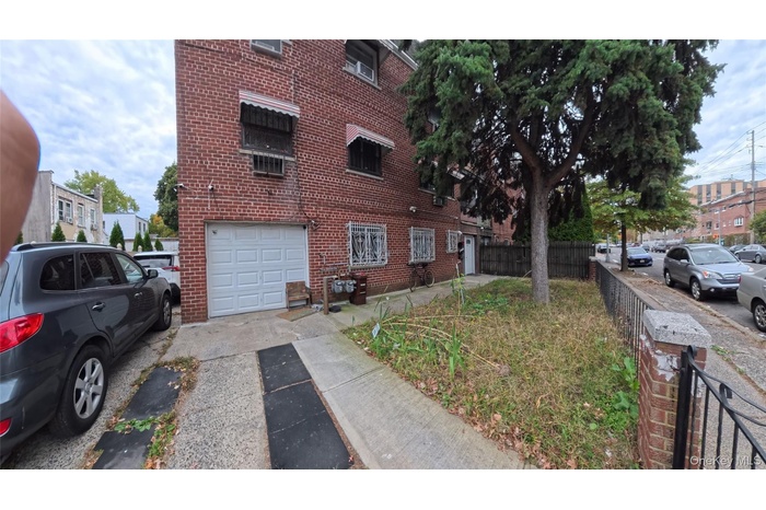 View of property exterior with brick siding, driveway, and a garage