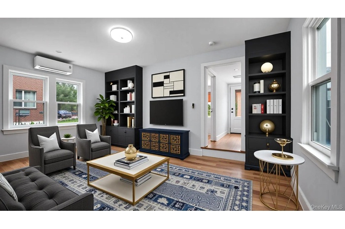 Living area featuring light wood-style floors, a wall unit AC, and built in features