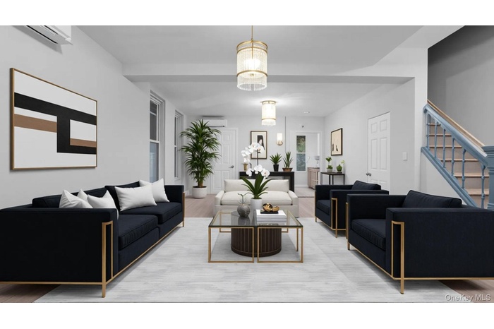Living room featuring wood finished floors, stairs, a wall unit AC, and a chandelier