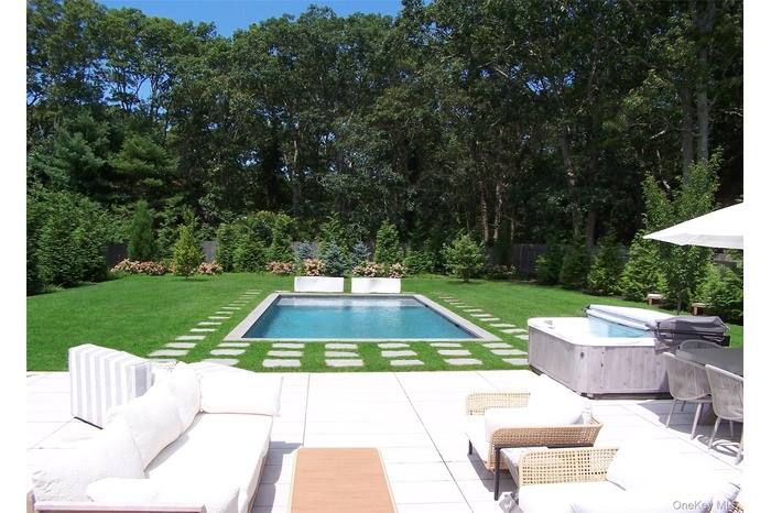 Swimming pool with a yard, outdoor lounge area, and a patio area