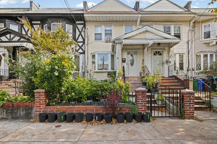 View of front of property with a fenced front yard, a gate, and roof with shingles