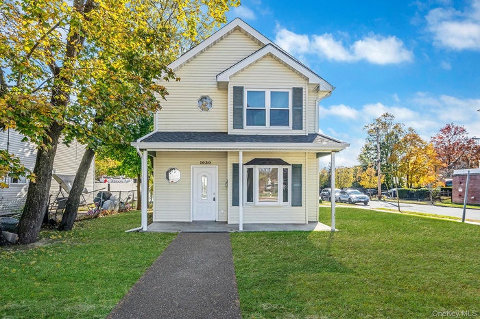 Traditional-style house featuring a porch and a shingled roof
