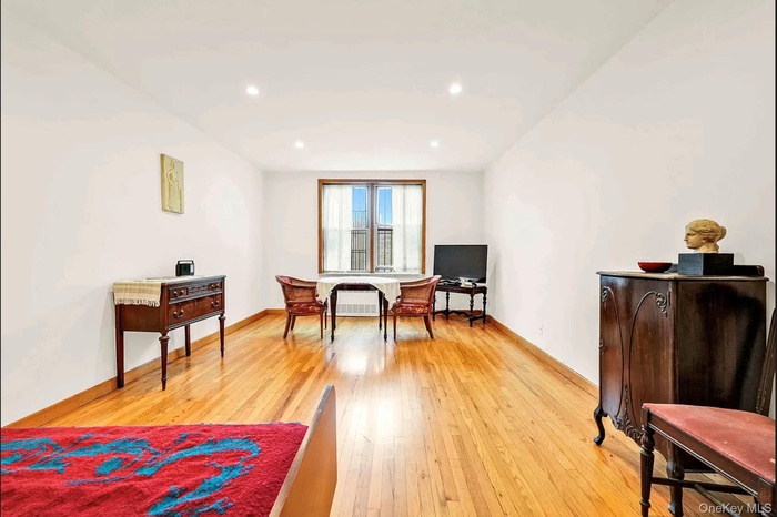 Sitting room featuring light wood-style flooring, recessed lighting, and a desk