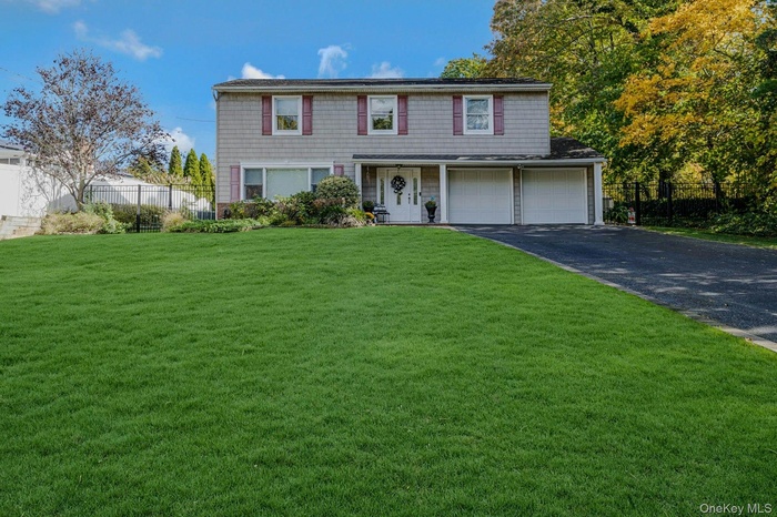 View of front of house featuring driveway, a garage, and covered porch