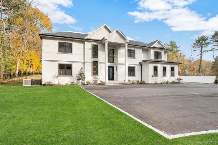View of front of house featuring a shingled roof and stucco siding