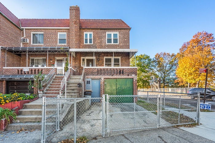 View of front of property featuring a gate, brick siding, a fenced front yard, driveway, and a garage