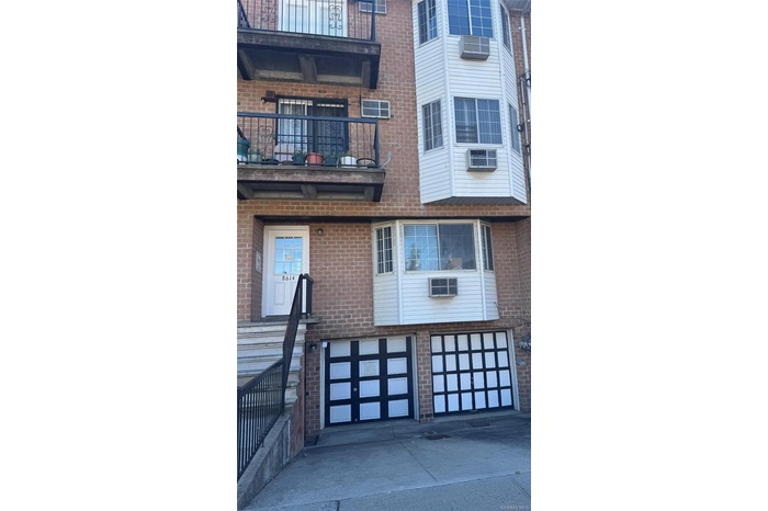View of property featuring an attached garage and concrete driveway