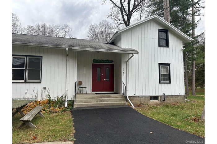 Entrance to property with a shingled roof